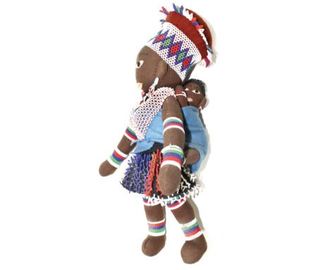 Kinderpuppe: wohl Grasland. Feine Stoffpuppe brauner Filz teilbemalt. Reich mit Glasperlen bestickt. Rücken mit Tragetuch und