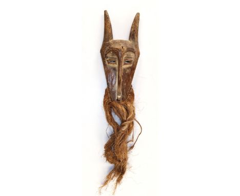 Lega Bart-Hörnermaske.: Maske mit heller Patina u. Resten weißer Caolinfärbung. Langer Bart aus Bast. L: ohne Bart. 40 cm.   
