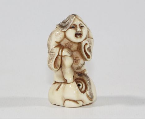 Okame erotische Netsuke.: Wohl Darstellung der Okame stehend auf einer No-Maske. Maske mit Kugelaugen. Lange Nase in Phallusf
