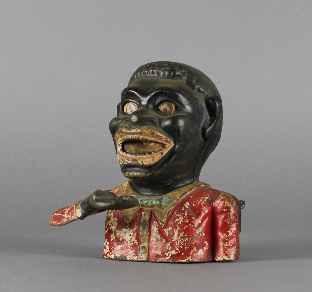 An old painted cast iron 'Sambo' money box, 16cm high Surface wear and light rusting