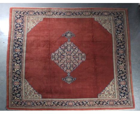 A large Sarouk style carpet. 368cm x 285cm. Patches of wear and staining.