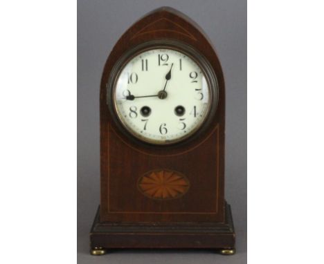 An Edwardian mahogany mantle clock, arched case, striking a coil. 29cm high. Coil stand loose, some scratching.