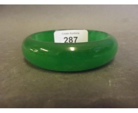 A Chinese green jade bangle, 3'' diameter 