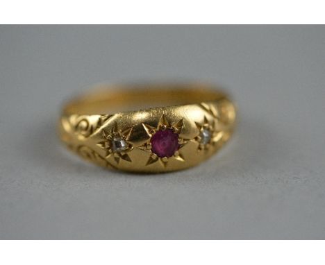 AN EARLY 20TH CENTURY RUBY AND DIAMOND GYPSY STYLE RING, two old mine cut diamonds and one round mixed cut ruby, scroll engra