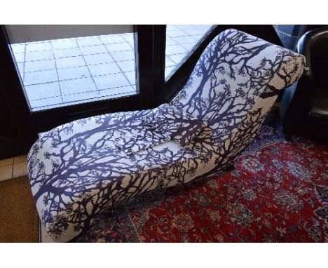 A MODERN UPHOLSTERED LOUNGER, with a tree print design