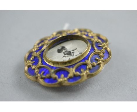 AN EARLY 20TH CENTURY GOLD PLATED BASSIE-TAILLE BLUE ENAMELLED BROOCH, scroll design with a photograph compartment (please no