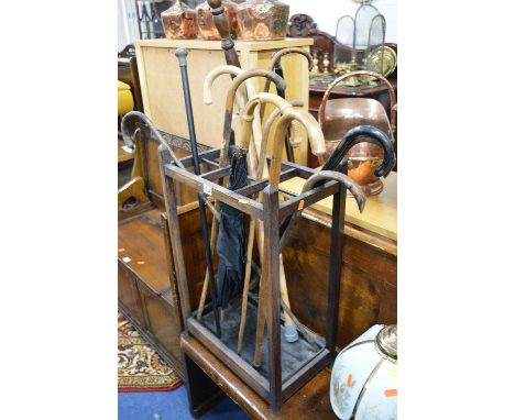 A STAINED OAK STICK STAND, with metal insert, containing a quantity of walking sticks including three silver topped sticks (s