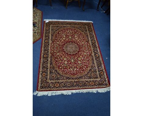 A KESHAN STYLE RUG, red, blue and gold ground, multi strap border, foliate design and central medallion, approximate size 162