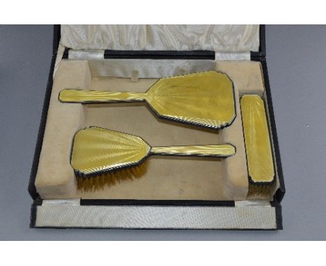A YELLOW ENAMEL AND SILVER THREE PIECE DRESSING SET, boxed