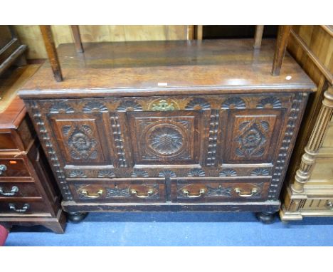 AN EARLY 20TH CENTURY CARVED OAK TRIPLE PANEL MULE CHEST, above two drawers with brass handles, approximate size width 112cm 