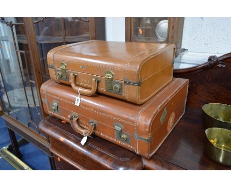 A SET OF TWO GRADUATING TAN LEATHER SUITCASES, Cornell label attached A.W.E. Stamped to each suitcase and travel labels to si