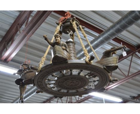 A STAINED OAK HANGING CENTRE LIGHT FORMED AS A SHIPS WHEEL, moulded with five rowing boats each with male figures to the prow