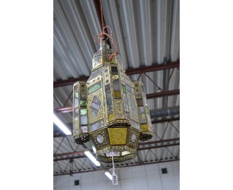 A BRASS FRAMED TURKISH STYLE HANGING CENTRE LIGHT FITTING, pierced dome above coloured and clear glass panels to an octagonal