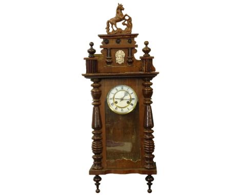 A late 19th/early 20thC Vienna style wall clock, the case mounted with a composition horse, the enamel type dial with Roman n