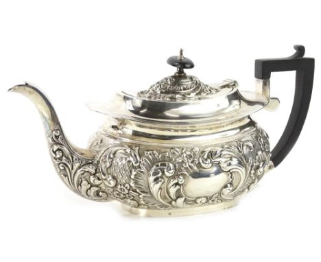 A late Victorian silver teapot, of rectangular form, embossed with scrolls etc., the lid with an ebonised knop and handle, on