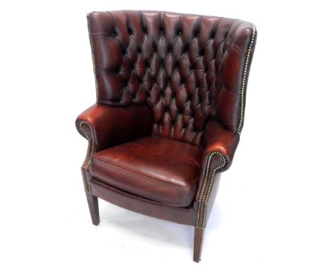 A mahogany and red leather button back porters chair, with brass studded decoration on square tapering legs.
