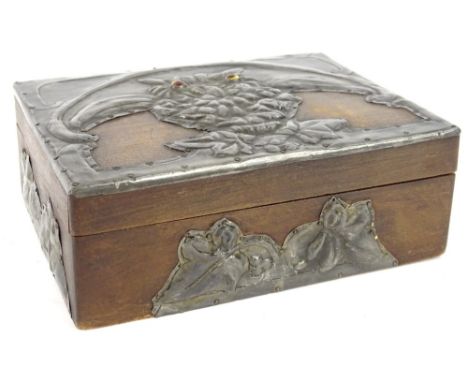 An early 20thC wooden cigarette box, mounted with arts and crafts hammered pewter design of an owl, with enamel eyes, in the 