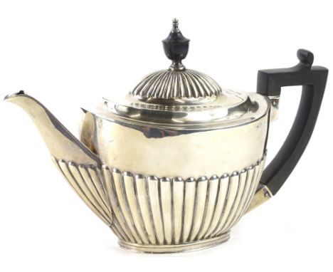 A late Victorian silver teapot, with part fluted body, ebonised knop and handle, London 1897, 14oz gross.