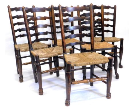 A Harlequin set of six Lancashire ash ladder back chairs, each with a rush seat on turned legs with stretchers.