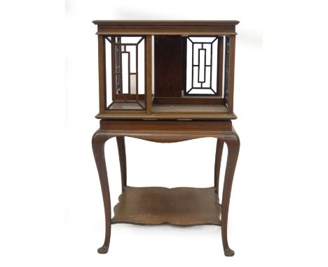 An Edwardian mahogany revolving bookcase, with boxwood strung and satin wood cross banded moulded top, over a revolving four 