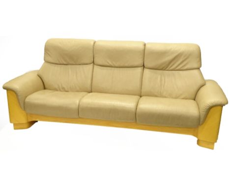 A Stressless cream leather three seat sofa, with satin birch veneered ends, etc., stamped Ekrones.