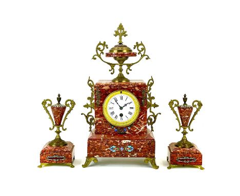 A French rouge marble, gilt metal and champleve enamel clock garniture. Circa 1880, with urn shape mount and side pieces, the