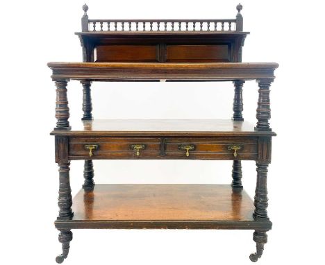 A late Victorian oak buffet by James Shoolbred &amp; Co. With a gallery top, turned column supports, two short drawers on cer