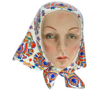 A Lenci Art Deco pottery wall mask. Designed by Elena König Scavini, modelled as a fashionable young woman wearing a colourfu