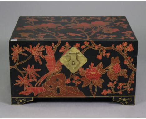 A Chinese black lacquered storage trunk having all-over red, gold, &amp; brown foliate decoration, with a hinged lift-lid, br