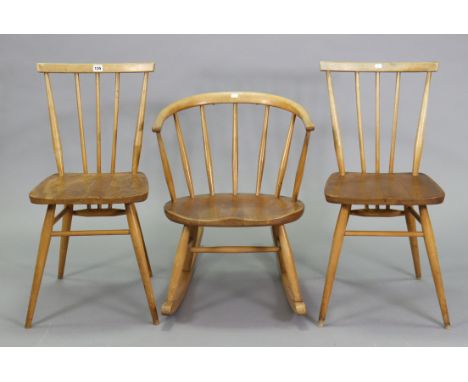 A pair of Ercol spindle-back dining chairs each with a hard seat, &amp; on round tapered legs with spindle stretchers; &amp; 