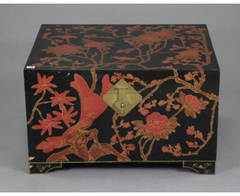 A Chinese black lacquered storage trunk having all-over red, gold, &amp; brown foliate decoration, with a hinged lift-lid, br