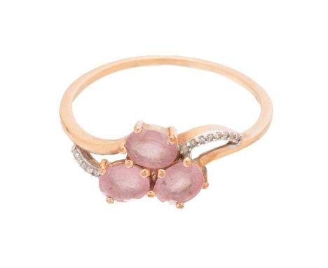 A 9ct gold, pink sapphire, and diamond dress ring, set with three oval cut pale pink sapphires, with curved rows of diamonds 