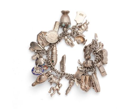 A silver curb link charm bracelet with a large number of charms including a reticulated fish, motorboat, folding comb and a p