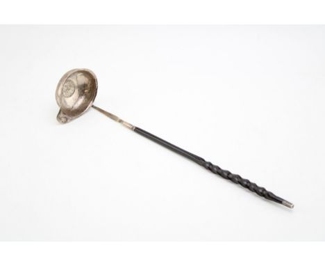 A George III silver toddy ladle, the oval bowl inset with 1787 half crown, with baleen twist handle.