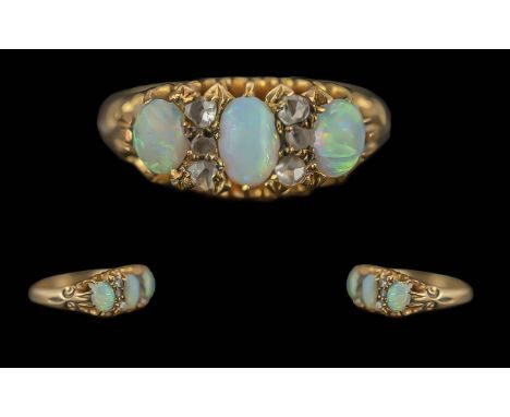 18ct Gold Three Stone Opal Ring set between diamond spacers. Fully hallmarked, circa 1900. Ring size O.