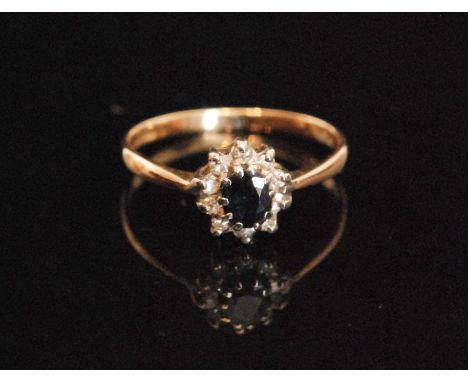 A 9ct hallmarked sapphire and diamond cluster ring, central sapphire within ten stone diamond surround, all stones claw set, 