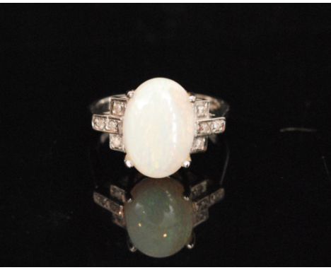 A 9ct hallmarked opal and diamond ring, central oval claw set opal flanked with four brilliant cut diamonds to each shoulder,