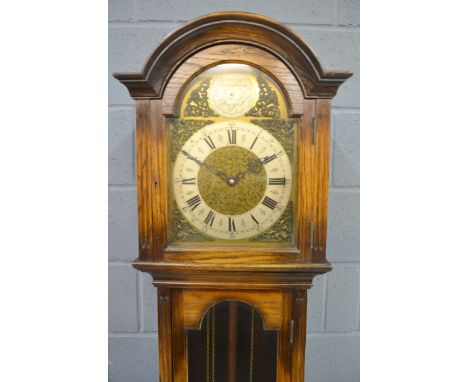 An early 20th Century oak veneered longcase clock with eight-day movement, with brass broken arch dial with silvered chapter 