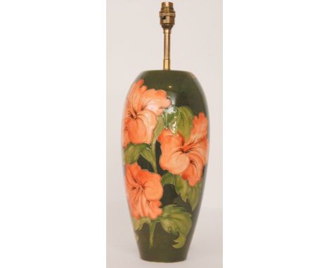 A large Moorcroft table lamp decorated in the Hibiscus pattern with coral flowers on green, height 37.5cm (excluding fittings