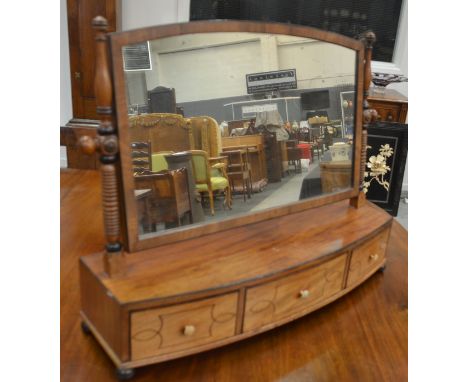 A George IV mahogany bow fronted toilet swing mirror, raised to bobbin-turned supports above three line-inlaid frieze drawers