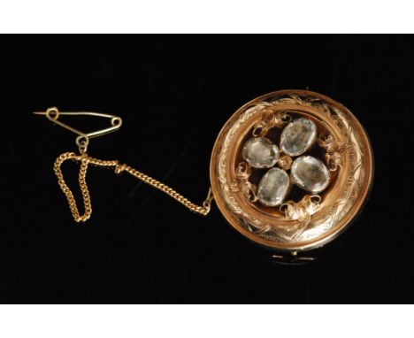 A Victorian 9ct circular mourning brooch centred by four oval colourless pastes, framed by a cushioned and engraved border, v