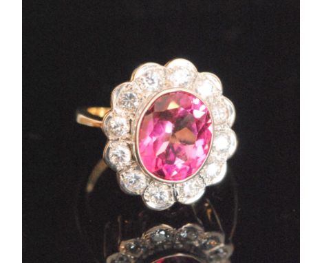 A 9ct hallmarked pink topaz and cubic zirconia cluster ring, central oval collar set topaz within a twelve stone surround, ri