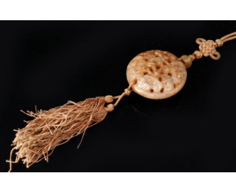 A Chinese Qing Dynasty carved and pierced jade pendant of pale celadon to brown colour, formed from two pierced domes decorat