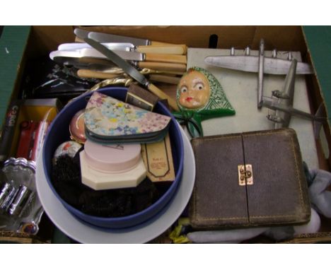 A mixed collection of items: savings bank, damaged silver hand mirror, mounted car mascot, cased spoons, faux bone handled bu
