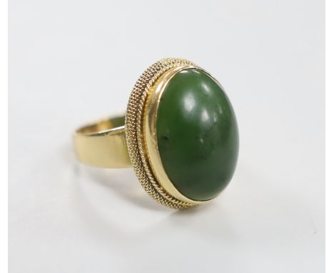 An 18k and green cabochon stone set dress ring. size Q/R, gross weight 12.1 grams.