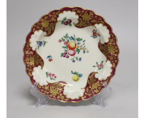 A Worcester small plate painted with fruit and flowers under a crimson and floral gilt border, 17.5cm diameter