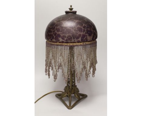 An Art Nouveau style metal lamp and glass shade with beaded fringe, 44cm high