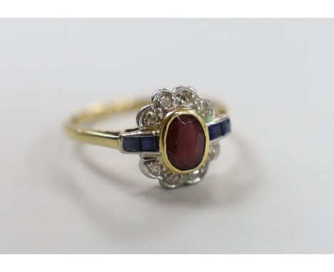 A 1920's/1930's yellow metal, ruby, sapphire and diamond set oval cluster ring, size O, gross weight 3.1 grams.
