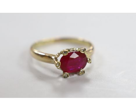 A yellow metal and single stone oval cut ruby and six stone diamond chip set ring, size L, gross weight 2.5 grams.