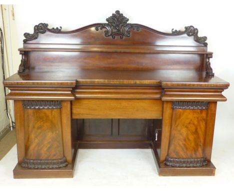 A Victorian mahogany twin pedestal sideboard, foliate carved gallery above a full width shelf on scrolling supports, base wit